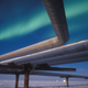A full moon helps illuminate the Alaskan pipeline under the faint glow of the Aurora Borealis near Milne Point, Alaska.